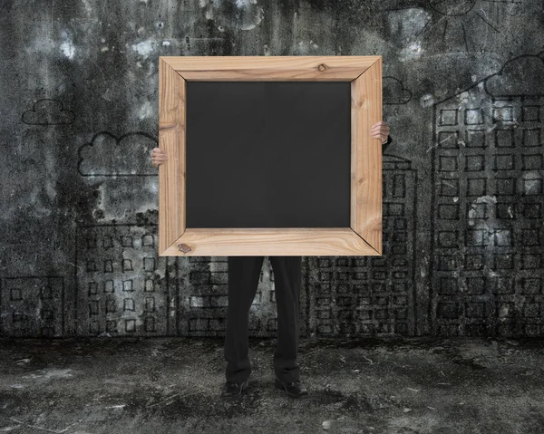 Man holding black blank chalkboard with cityscape doodles mottle — Stock Photo, Image