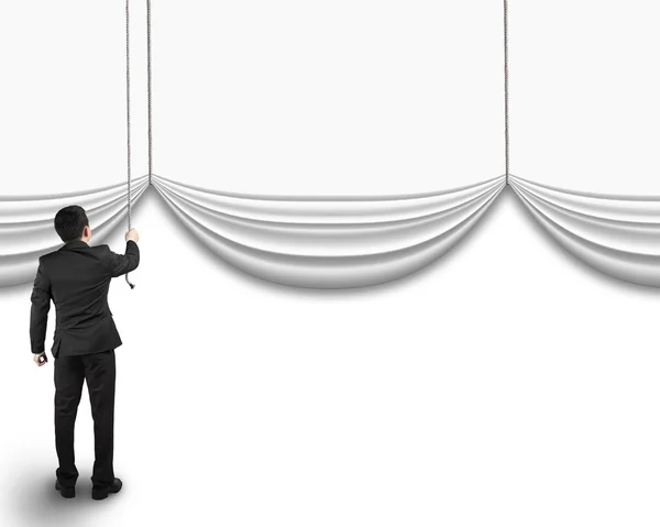 Businessman pulling open blank curtain with empty behind — Stock Photo, Image