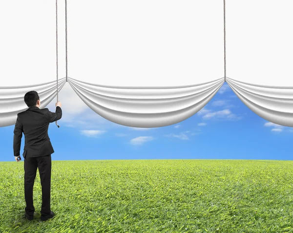 Businessman pulling open blank white curtain revealed natural sk — Stock Photo, Image