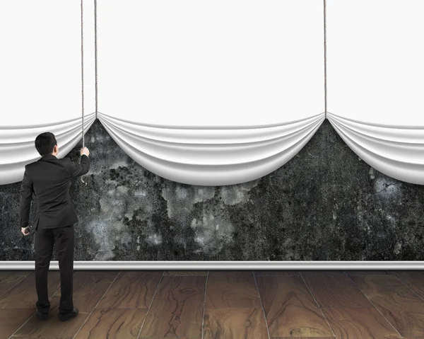 Businessman pull open blank white curtain covered dirty concrete — Stock Photo, Image