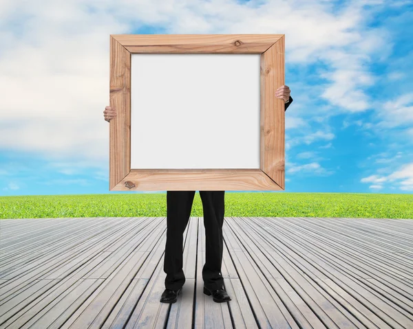 Man met leeg wit bord met houten frame — Stockfoto