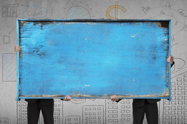 Deux hommes d'affaires tenant vieux tableau blanc bleu en bois — Photo