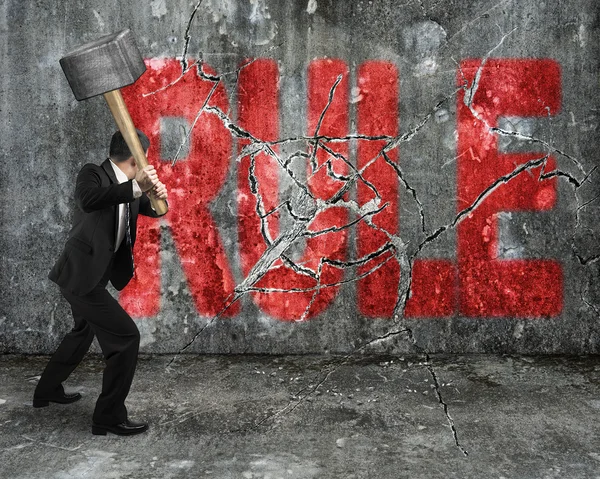 Businessman using sledgehammer cracking red rule word broken — Stock Photo, Image