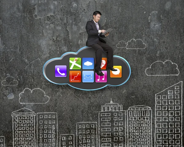 Empresário usando tablet na nuvem negra com ícones de aplicativos — Fotografia de Stock