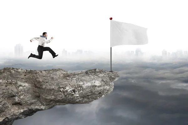 Hombre corriendo a la bandera blanca en el acantilado con paisaje urbano nublado — Foto de Stock