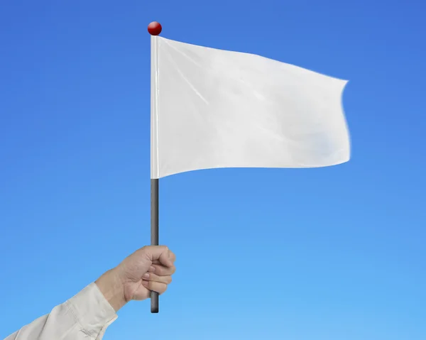 Рука людини тримає порожній білий прапор ізольовано на синьому — стокове фото