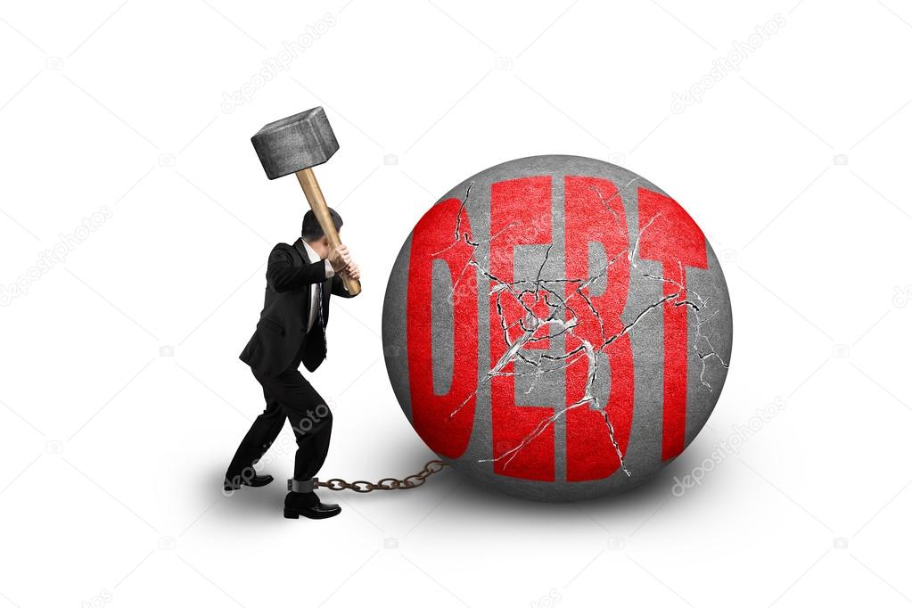 businessman holding hammer hitting cracked DEBT ball isolated on