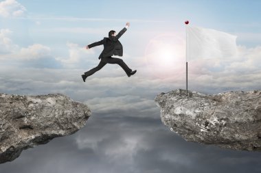 Businessman jump on cliff with blank flag and sunlight cloudscap clipart