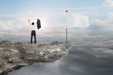man cheering on cliff with blank flag and sunlight cloudscapes