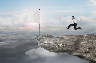 man running to blank white flag on cliff with sunlight