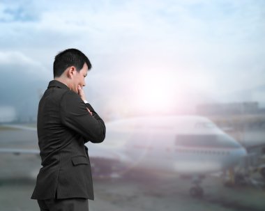 A businessman looking airplane at an airport