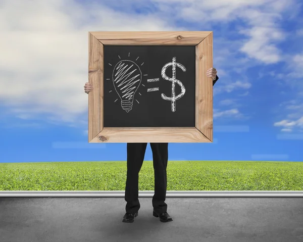 Man holding blackboard with hand-drawn ideas equal money and sky — ストック写真