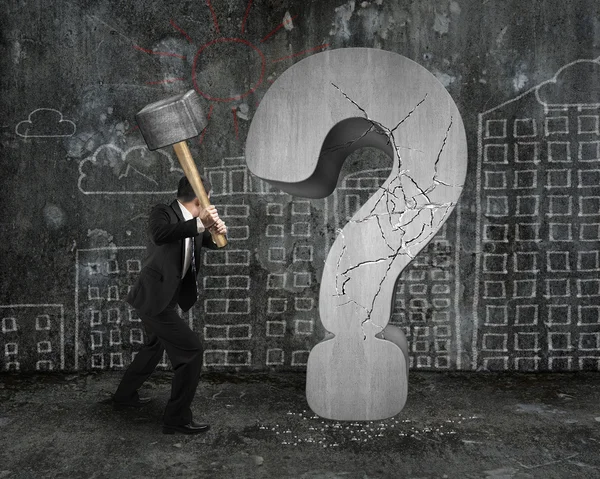 Businessman holding hammer cracked question mark with city build — ストック写真