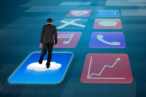Rear view businessman surfing on shiny app icons tech background — Zdjęcie stockowe