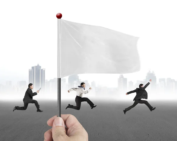 Hand holding flag with three businessmen running and cityscape b — Stok fotoğraf