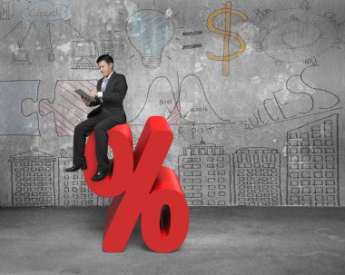 Using tablet businessman sitting on red percentage sign with doo