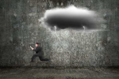 Running businessman holding tablet with dark clouds raining and 