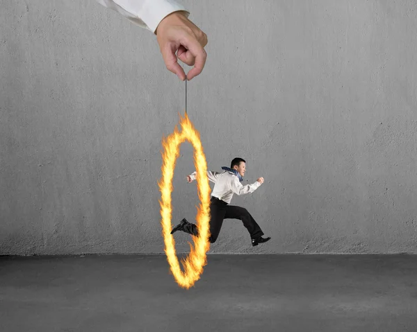 Man jumping through fire circle hand holding with concrete wall — Stock Photo, Image