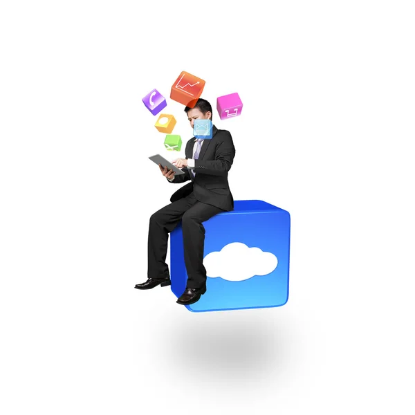 Businessman using smart pad sitting on cloud app icon — Stockfoto