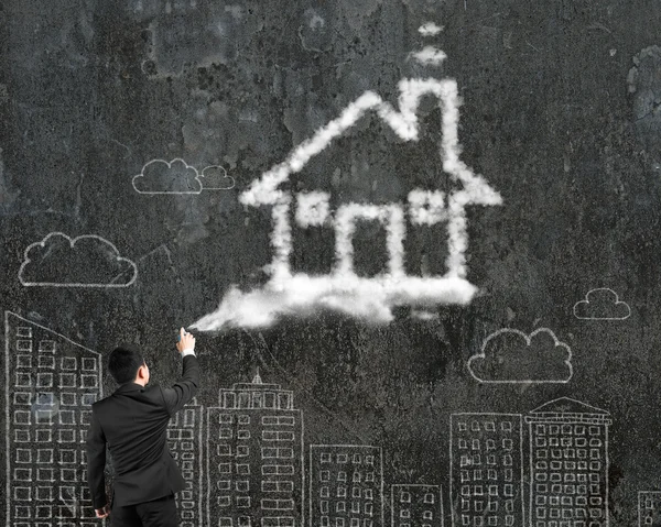 Uomo d'affari spruzzando casa a forma di nuvola vernice con paesaggio urbano dood — Foto Stock