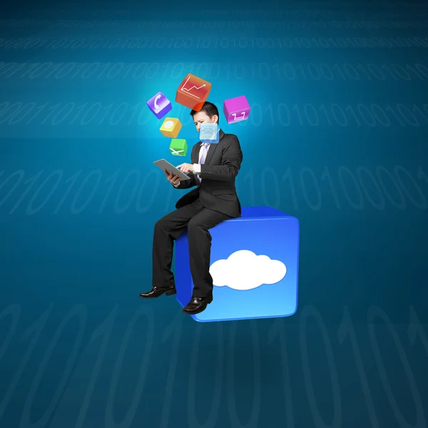 Businessman using tablet sitting on cloud app icon with tech — 图库照片