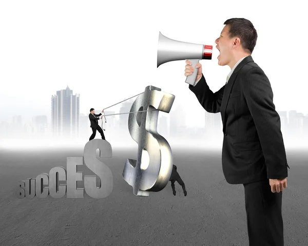 Businessman using megaphone to command employees moving metal do — Stock Photo, Image