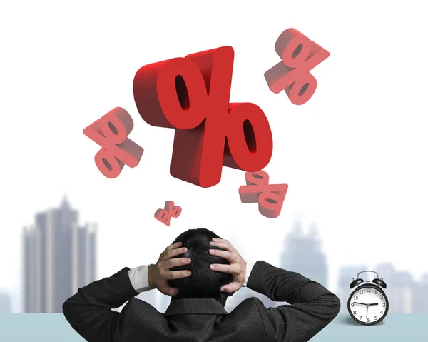 Бизнесмен держит голову с красными процентами знаков и блоком — стоковое фото