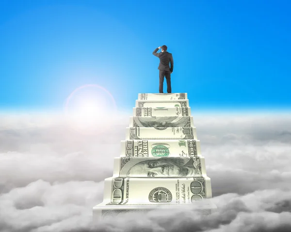 Businessman reaching the top of money stairs with sunlight cloud — Stok fotoğraf