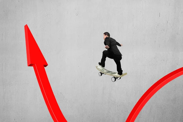 Businessman skateboarding on red arrow pointing up with concrete — Stock Photo, Image