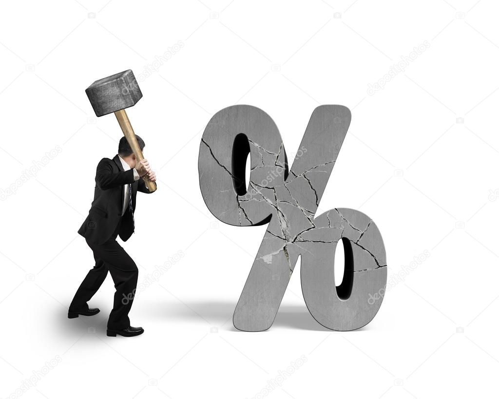 Businessman holding sledgehammer hitting cracked percentage sign