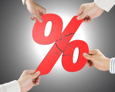 Group of business people assembling broken red percentage sign