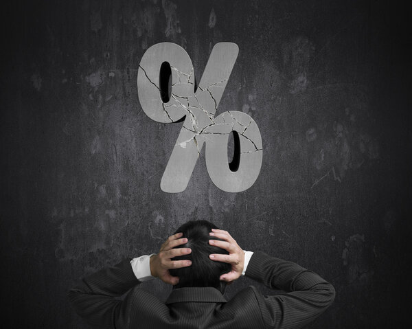 Businessman hand head with cracked percentage sign on concrete w