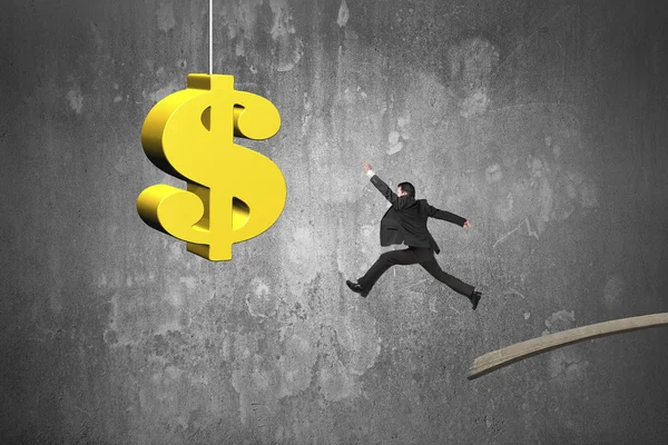 Businessman jumping from wooden board to golden dollar sign