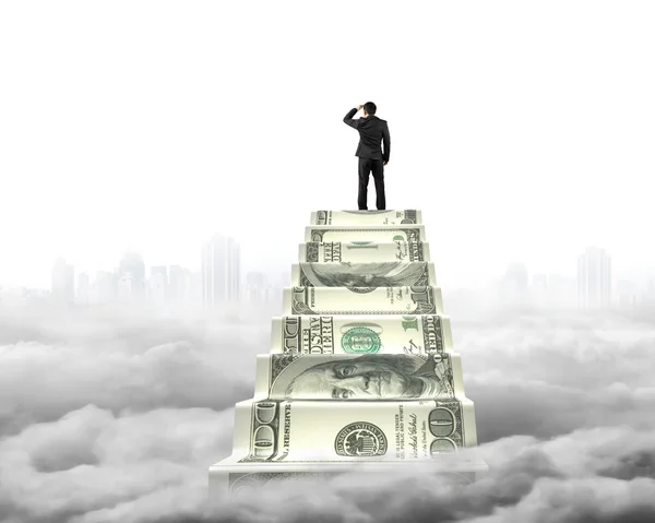 Businessman reaching the top of money stairs with cityscape clou — Stok fotoğraf