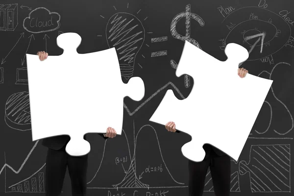 Two business people assembling blank white jigsaw puzzles with d — Stok fotoğraf