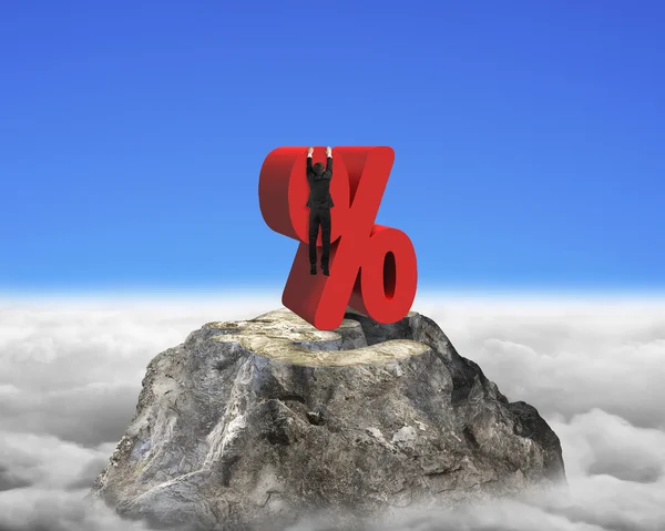 Businessman hanging on red percentage sign with euro peak clouds — Zdjęcie stockowe