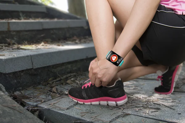 Sport woman tying shoelaces wearing health sensor smartwatch wit — Stok fotoğraf