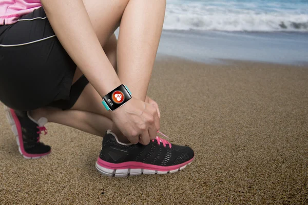 Deporte mujer atando cordones de zapatos con sensor de salud smartwatch ingenio — Foto de Stock