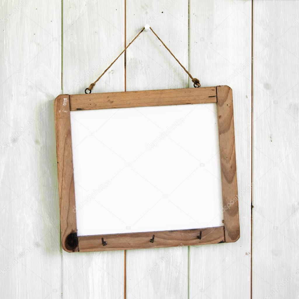 Blank message board hanging on retro white wooden wall