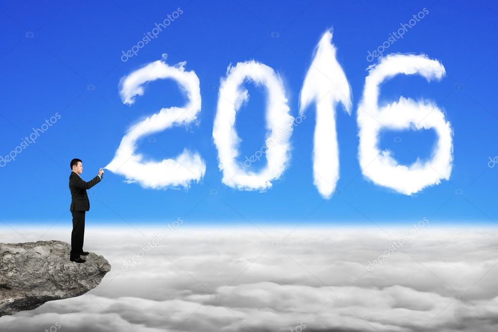 Businessman spraying white 2016 year cloud shape in sky cloudsca