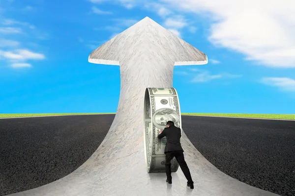 Uomo d'affari spingendo denaro cerchio sulla strada di marmo freccia con cielo — Foto Stock
