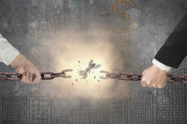 Businessman pulling rusty iron chains broken with business doodl