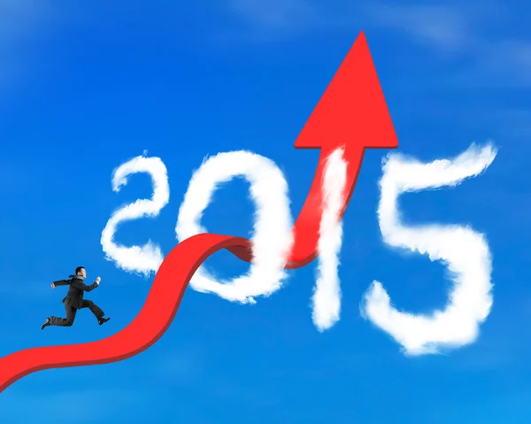 Businessman running on arrow upward trend line through 2015 clou — Stock Photo, Image