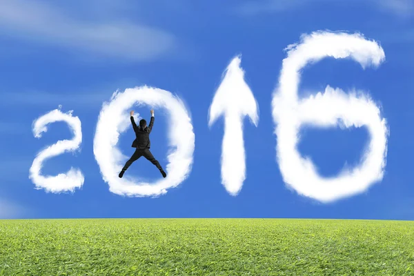 Jumping businessman cheering 2016 arrow up shape clouds with gra — Stockfoto