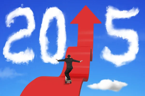 Skateboarding hombre de negocios en la flecha hacia arriba camino con 2015 nubes — Foto de Stock