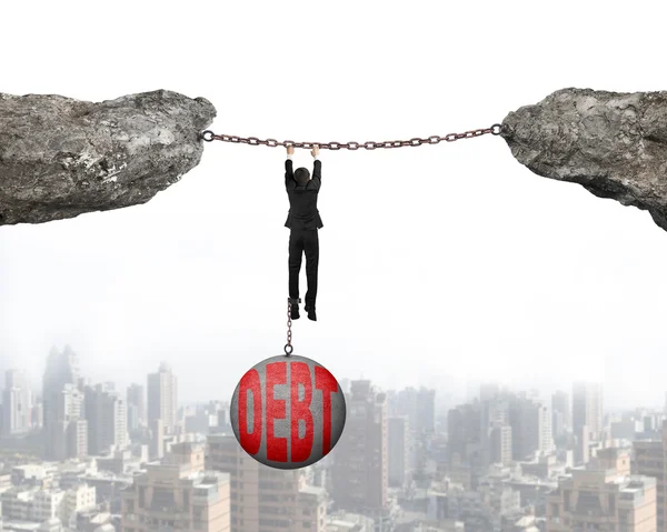 Businessman shackled by debt ball hanging on chains connected cl — Stock Photo, Image