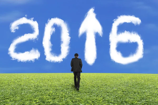 Empresário caminhando para branco 2016 nuvem e grama céu azul — Fotografia de Stock