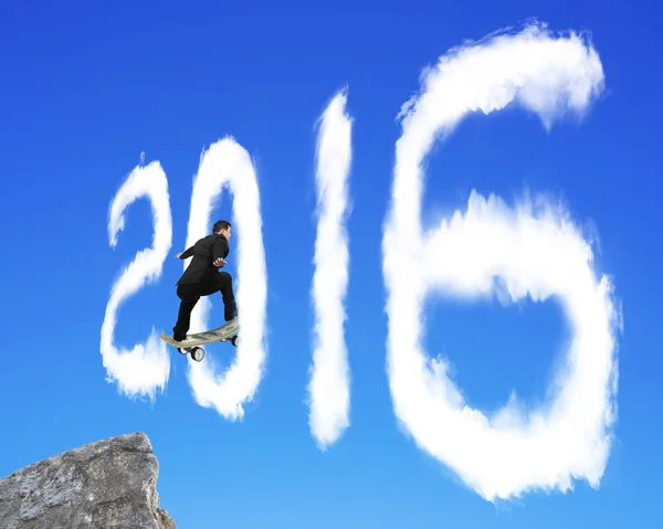 Skateboarding hombre de negocios que pasa a través de 2016 nube forma en bl — Foto de Stock