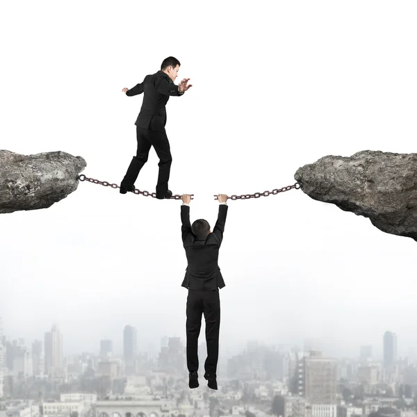 Businessman walking on cracking rusty iron chains another man ho — Stock Photo, Image