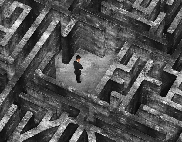 Businessman standing in center of 3D old mottled concrete maze — Stock fotografie